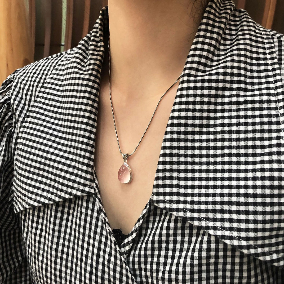 Close-up detail of ice-cut pink rose quartz crystal drop pendant